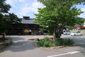 un bâtiment avec un arbre en face d'un parking dans l'établissement Onoan, à Hida