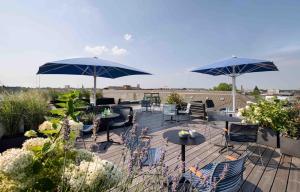 eine Terrasse mit Tischen, Stühlen und Sonnenschirmen in der Unterkunft OBERDECK Studio Apartments - Adults only in Hamburg