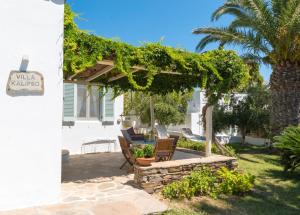 a patio with chairs and a pergola at Kavos Hotel Naxos in Agios Prokopios