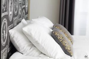 a pile of pillows sitting on top of a bed at L’Emmaline in Chambéry