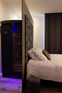 a bedroom with a bed with a black headboard at L’Emmaline in Chambéry