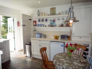 uma cozinha com uma mesa com um vaso de flores em Fleur Cottage Killorglin by Trident Holiday Homes em Killorglin