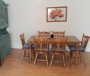 uma sala de jantar com uma mesa de madeira e cadeiras em 18A Moore Bay Holiday Homes by Trident Holiday Homes em Kilkee