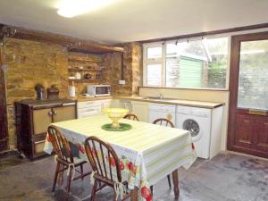 eine Küche mit einem Tisch und Stühlen sowie eine Küche mit einem Herd in der Unterkunft The Lodge Rossbeigh by Trident Holiday Homes in Glenbeigh