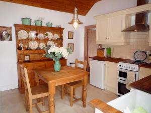 uma cozinha com uma mesa de madeira com um vaso de flores em Kizzie Cottage Killorglin by Trident Holiday Homes em Killorglin