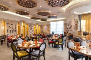 Holiday Inn - Suites Kuwait Salmiya, an IHG Hotel في الكويت: مطعم فيه طاولات وكراسي في الغرفة