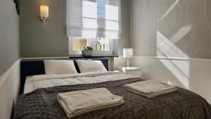 a bedroom with a bed with two towels on it at Apartament w samym sercu Opola 2 in Opole
