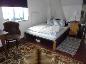 a bedroom with a bed and a chair and a rug at Ferienhaus am Geißnhof in Weiden