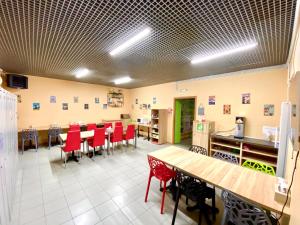 a dining room with red chairs and tables at Aloha Capsule Hotel in Vladivostok