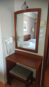 a mirror and a dresser in a room at Economy Hotel in Athens