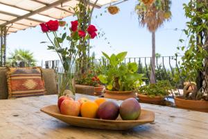 a bowl of fruit on a wooden table with flowers at Cortijo Boutique Marbella in Marbella
