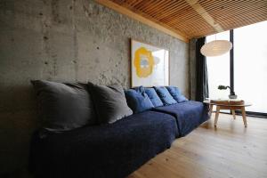 un sofá azul sentado en una sala de estar en Sunny Day Hostel en Takamatsu