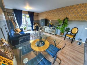 a living room with a table and blue chairs at Portobella Airport Aparthotel - Self Check in in Otopeni