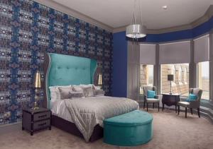 a bedroom with a bed and a blue wall at Richmond Park Hotel in Boʼness
