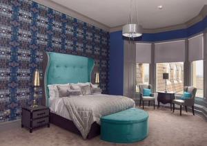 1 dormitorio con cama y pared azul en Richmond Park Hotel, en Boʼness