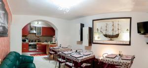 un soggiorno con tavoli e una cucina con una nave appesa al muro di B&B Bovianum a Boiano