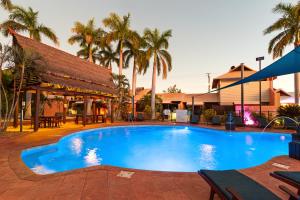 a large blue swimming pool next to a building at Bali Hai Resort & Spa in Broome