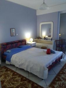 sypialnia z dużym łóżkiem i lustrem w obiekcie Blue Sky on the Sea Appartments w Atenach