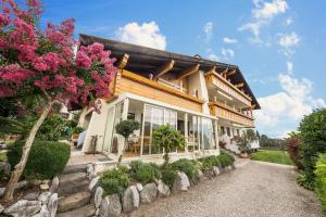 ein Haus mit rosa Blumen davor in der Unterkunft Residence Kronstein - Fewo 8 in Tisens