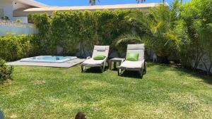 a yard with two chairs and a hot tub at Villa Palmera in Maspalomas