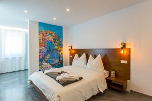 ガインベルクにあるZum kleinen Italiener - Ristorante Pizzeria Pensionのベッドルーム1室(壁に絵画が描かれたベッド1台付)