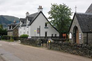 a white building on the side of a street at Duart Cottage in Glencoe