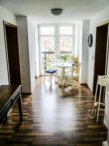 a living room with a table and a table and chairs at Zur Dorfschänke DEGGENDORF Ferienwohnung,Apartment, Hotelzimmer in Deggendorf