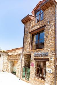 ein Backsteingebäude mit Fenstern und einem Balkon in der Unterkunft Apartamento Abuela Benita in Cebreros