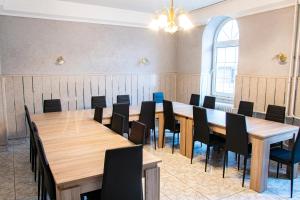 una sala conferenze con tavoli e sedie in legno di KOMPLEX -Rendezvénytermek-Panzió-Apartman-Irodák- a Mátészalka