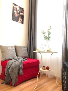 ein rotes Sofa im Wohnzimmer mit einem Tisch in der Unterkunft "Be my guest" near metro station! in Wien