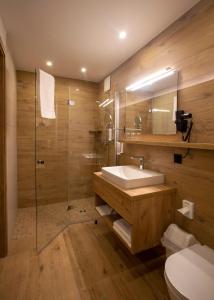 a bathroom with a sink and a shower and a toilet at Steig-Alm Hotel Superior in Bad Marienberg