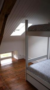 a attic room with two bunk beds and a skylight at WW Hostel & Suites in Coimbra