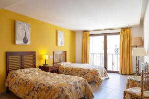 a hotel room with two beds and a balcony at Apartamento Abuela Benita in Cebreros +92 photos