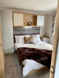 a bedroom with a large bed with a wooden headboard at The Lizard Bluewater in Helston