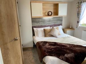 a bedroom with a large bed with a wooden headboard at The Lizard Bluewater in Helston
