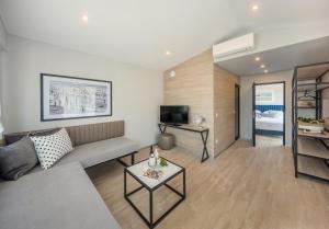 sala de estar con sofá y TV en Gava Waterman Milna Resort – All Inclusive, en Milna