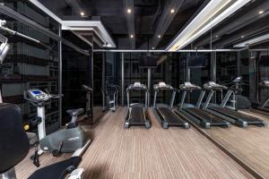 a gym with several treadmills and elliptical machines at The Mercer in Hong Kong