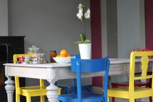 uma mesa com quatro cadeiras e uma tigela de laranjas em Liotte'sCorner Guesthouse em Sprimont