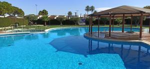 una gran piscina azul con sombrilla en Camping San Javier, en San Javier