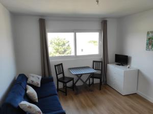 a living room with a blue couch and a table at Appart' Islande in Le Château-dʼOléron