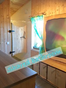 1 dormitorio con ducha y bañera con ventana en Wild Caribou's Wildwood Cabin, en Lakselv