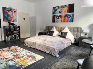 1 dormitorio con 1 cama y una pintura en la pared en GelsenDesign - Gemütliches Studio-Apartment en Gelsenkirchen