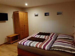 Schlafzimmer mit einem Bett und einem Holzschrank in der Unterkunft Pension Lehmann in Radebeul
