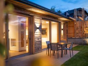 a patio with a table and chairs on a deck at Aura Chalets - Nr 1 in Castelrotto