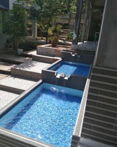 una gran piscina con 2 sillas. en AAL Homestay en Sabong