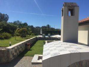 a building with a stone wall and a clock tower at Relaxing Villa Cefalù - Private Pool & Beach Walk by flAle's in Cefalù