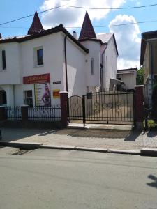 uma casa branca com uma cerca preta ao lado de uma rua em Sadyba Anzhelika em Truskavets