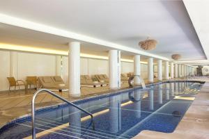 a pool in a hotel with chairs and tables at Hotel Es Port in Port de Soller