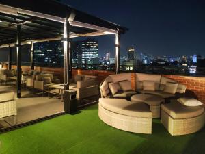 eine Dachterrasse mit Stühlen und Stadtblick in der Unterkunft Erian Hotel in Jakarta