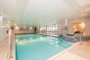 a large swimming pool with blue water in a building at New Place in Fareham